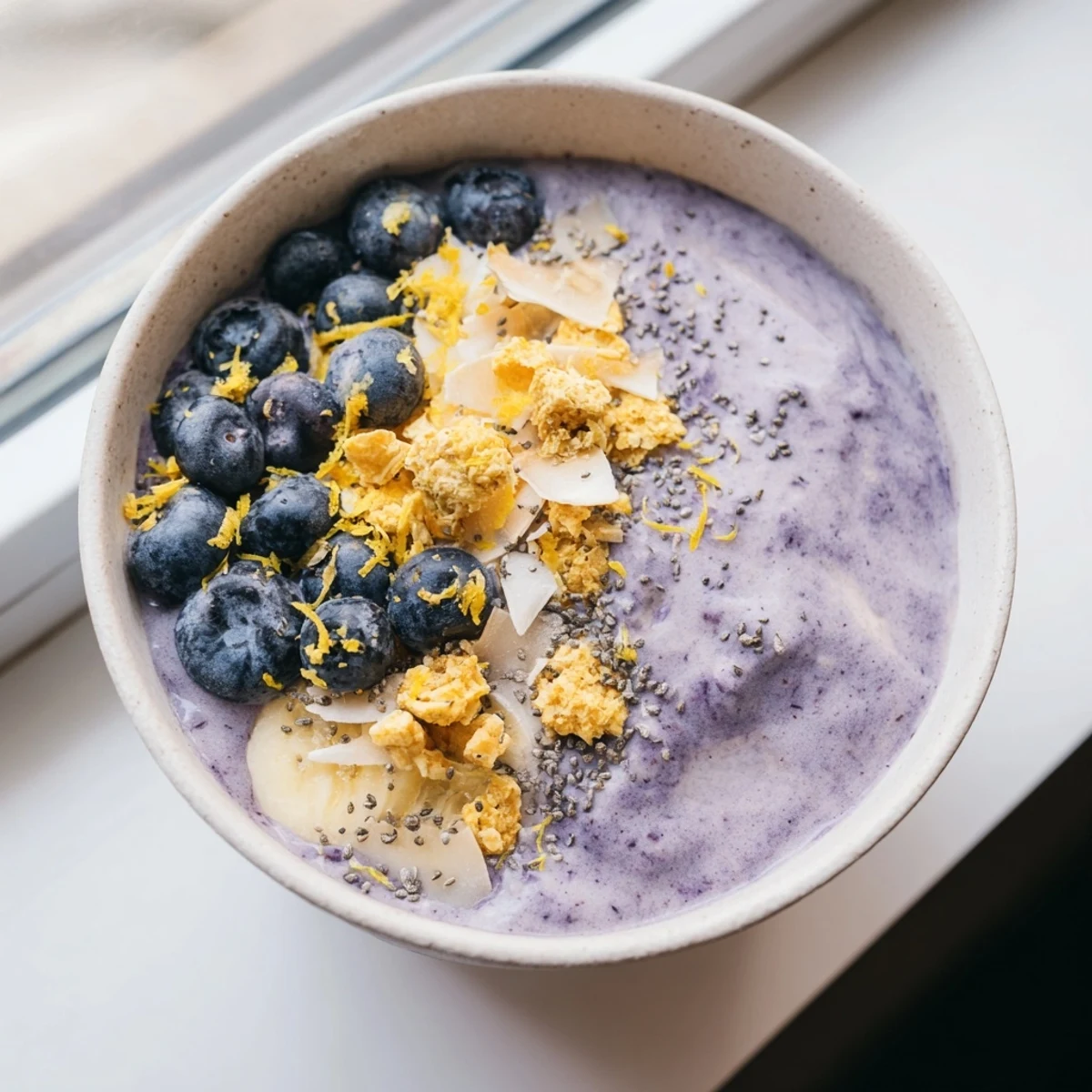 Refreshing Lemon Blueberry Smoothie Bowl recipe with a sweet lemon zest garnish, perfect for a quick, nourishing snack.
