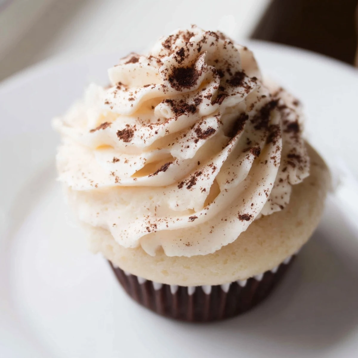 A close-up shows one Irish Cream Cupcake with a swirl of creamy frosting, its crumb moist and tender beneath.  