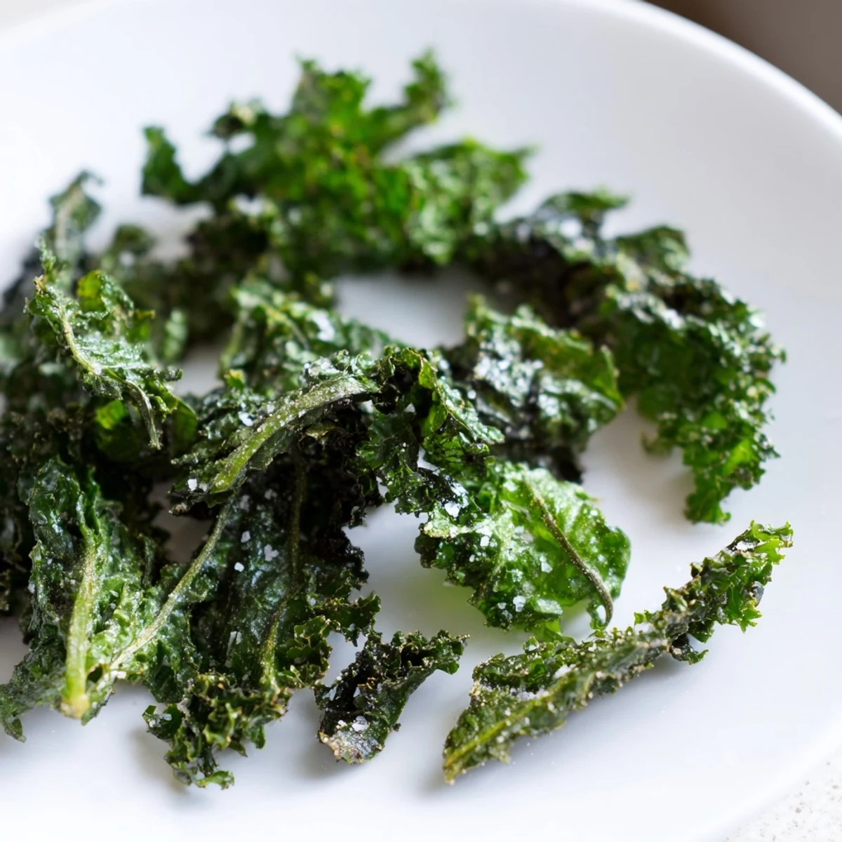 Healthy, oven-baked green kale chips with sea salt, arranged neatly on a tray for easy snacking.  