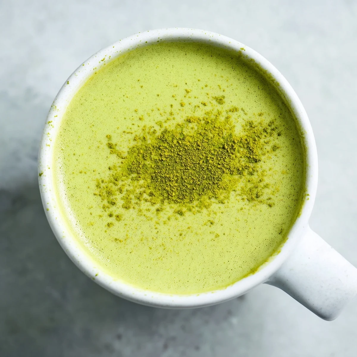 Sip on this creamy Green Matcha Latte with Oat Milk, poured into a rustic mug for a cozy, vegan-friendly treat.