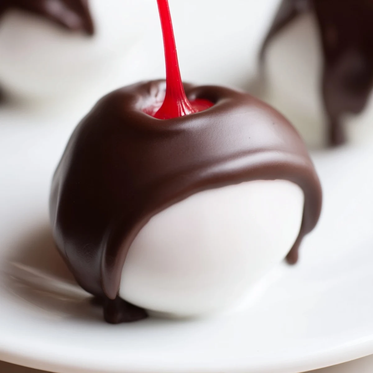 Decadent homemade chocolate covered cherries with a liquid fondant center, arranged elegantly on a white plate for a festive treat.