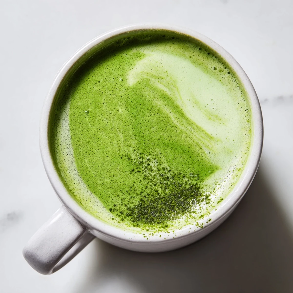 Green Matcha Latte with Oat Milk and Honey served iced in a tall glass with a bamboo straw.