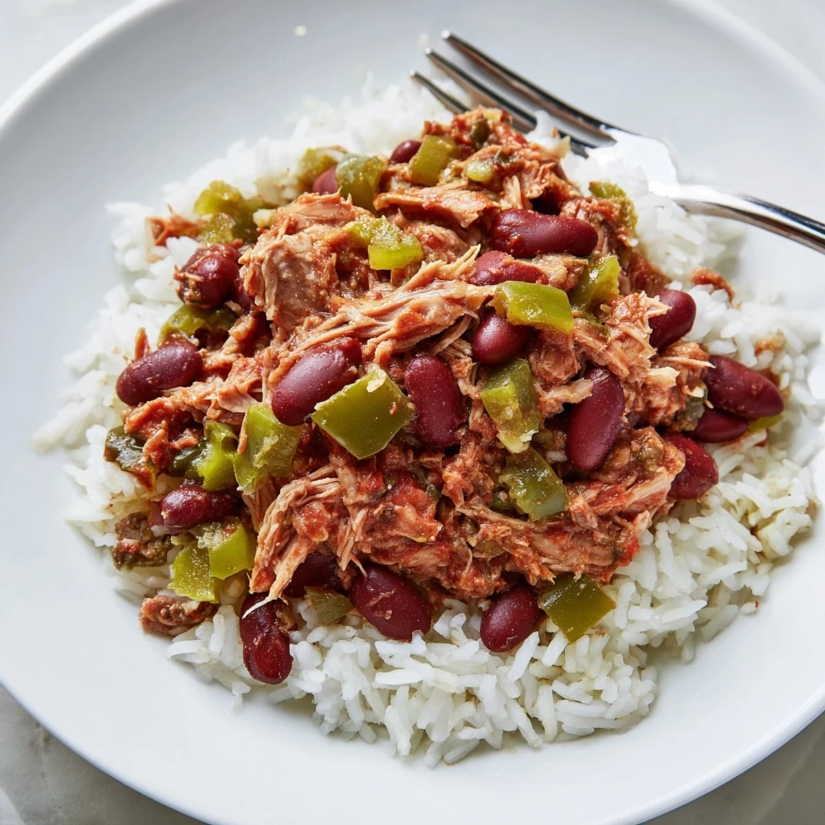 Savory Creole Red Beans and Rice featuring tender smoked turkey, bell peppers, and a sprinkle of cayenne over steamed rice.