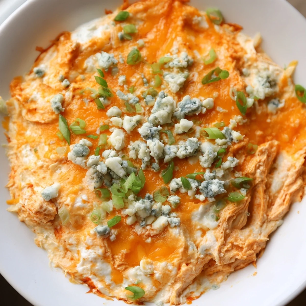 Creamy Keto Buffalo Chicken Dip with melted cheese and shredded chicken in a baking dish.  