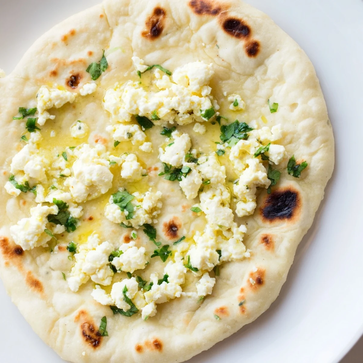 Golden-brown Cottage Cheese Garlic Naan fresh off the skillet, brushed with melted butter and flecked with fresh herbs.