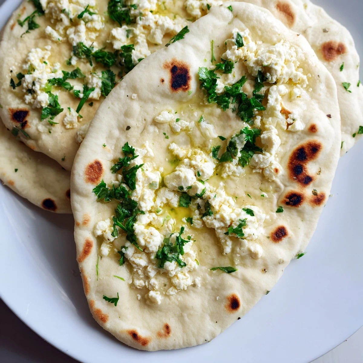 Warm, freshly baked Cottage Cheese Garlic Naan displaying a bubbly crust and stuffed with creamy cottage cheese filling.