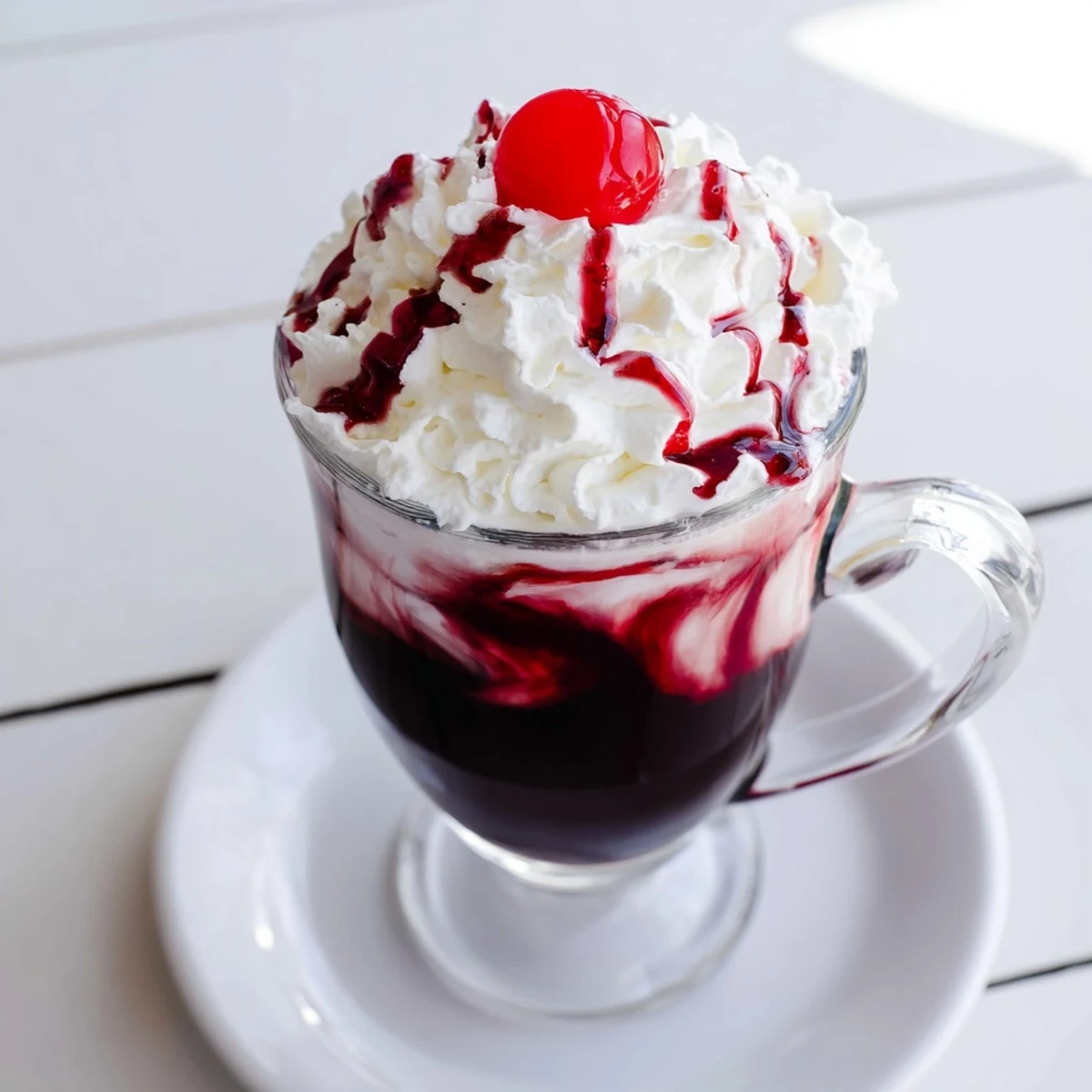 A vibrant Viral Cherry Vanilla Latte served hot with cherry drizzle on top.
