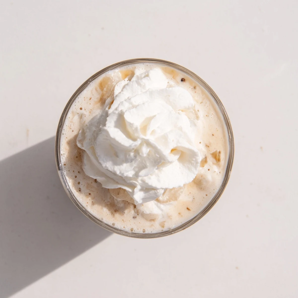 Homemade Starbucks Vanilla Bean Frappuccino blending milk and ice cream, poured over ice for a refreshing cold coffee treat.
