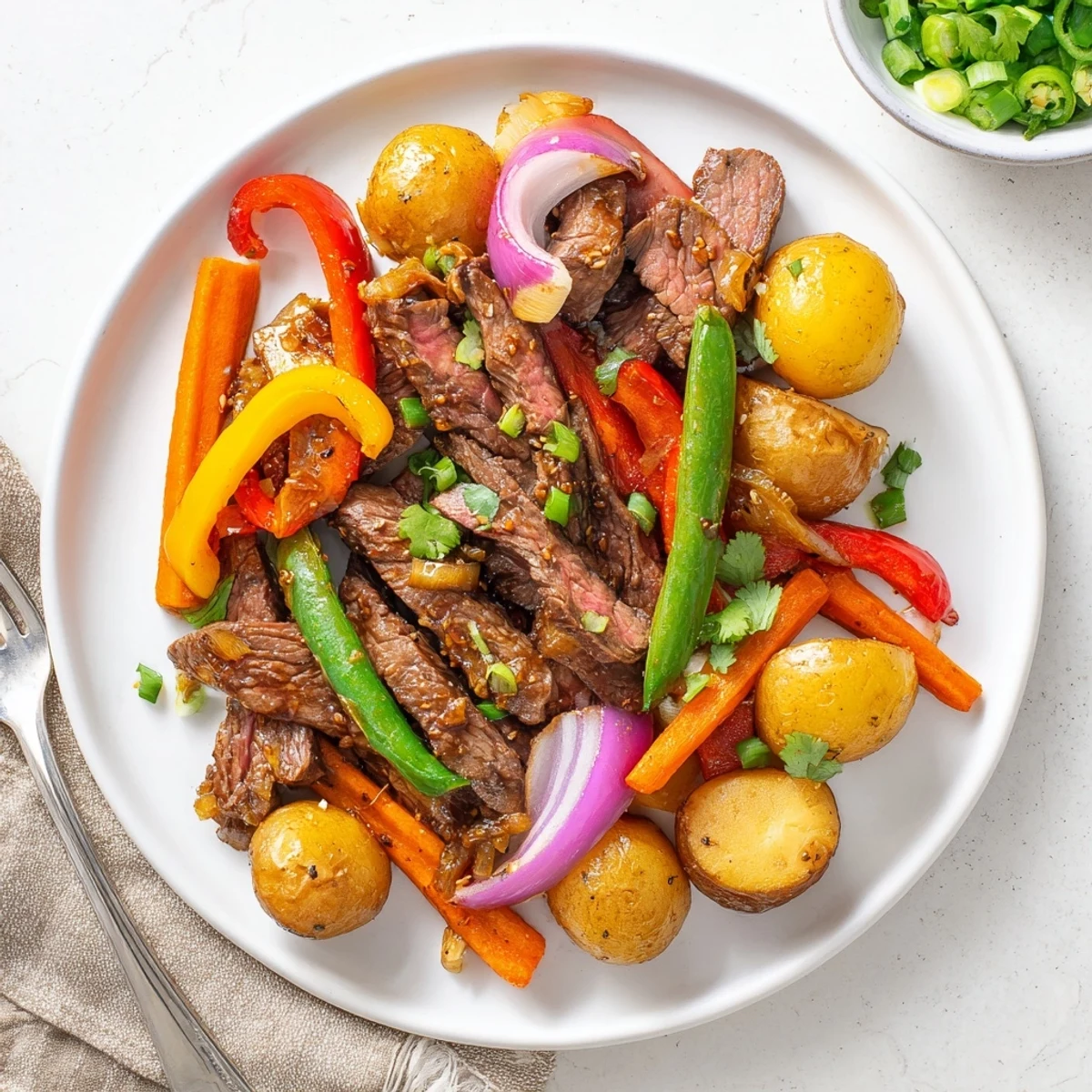 Golden-brown beef and vibrant bell peppers sizzling on a Blackstone griddle for the Blackstone Cowboy Stir Fry Dinner, served with scallions.