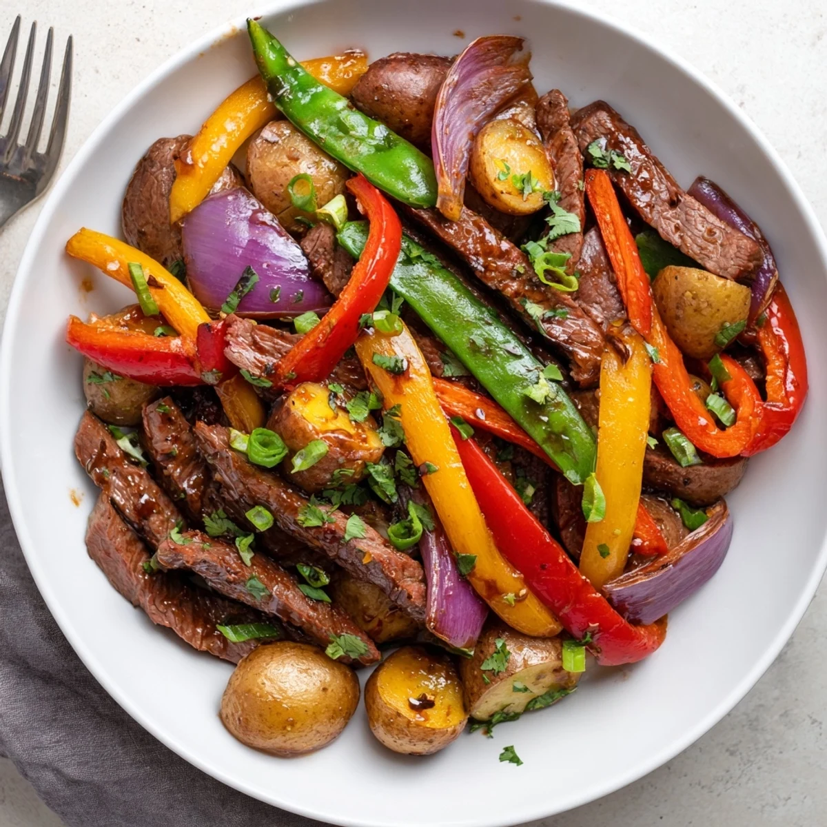 The Blackstone Cowboy Stir Fry Dinner features juicy beef strips, crisp snap peas, and tender potatoes coated in a savory sauce on the griddle.