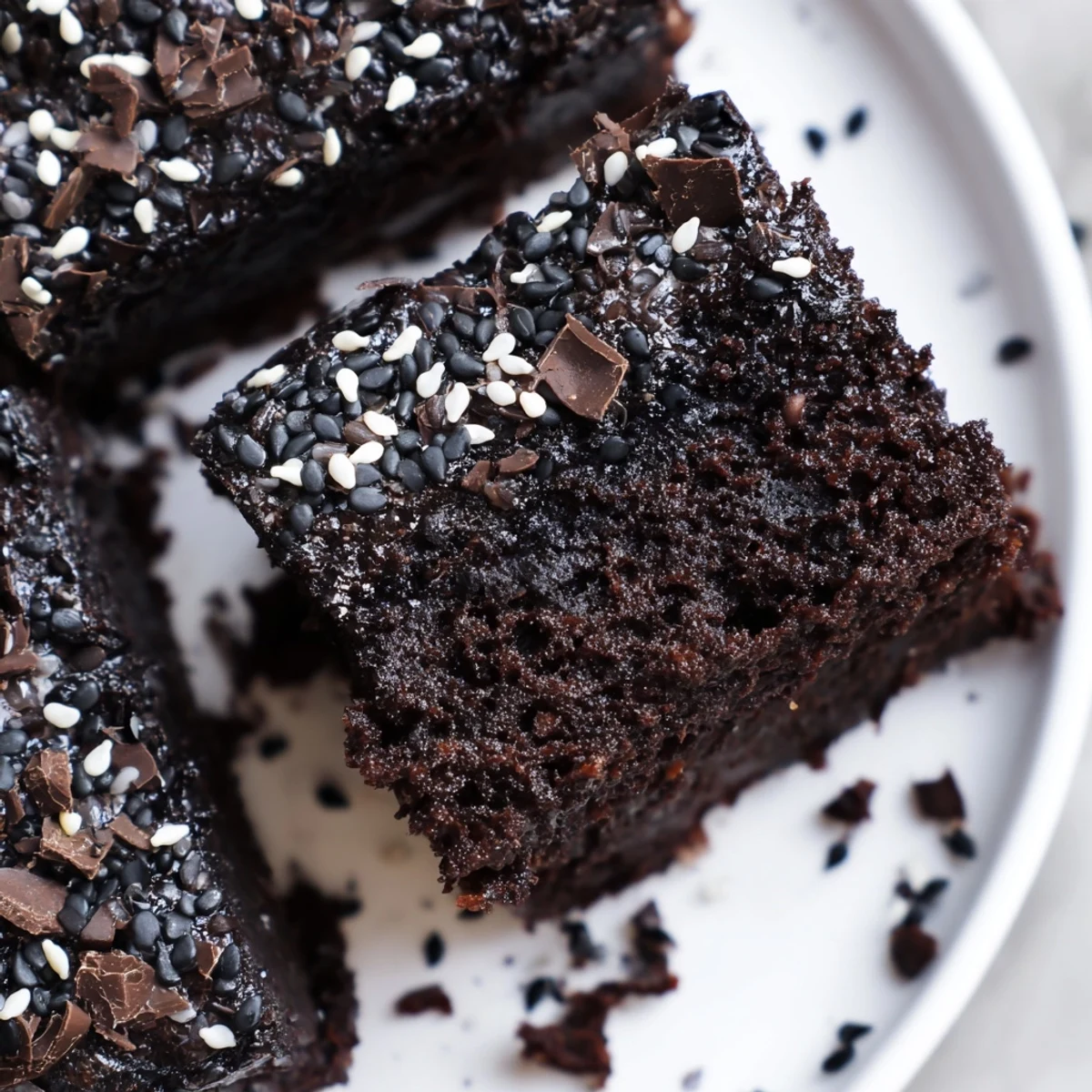 Fudgy Black Sesame Brownies cooling on a wire rack, studded with dark chocolate chunks and crumbly edges.