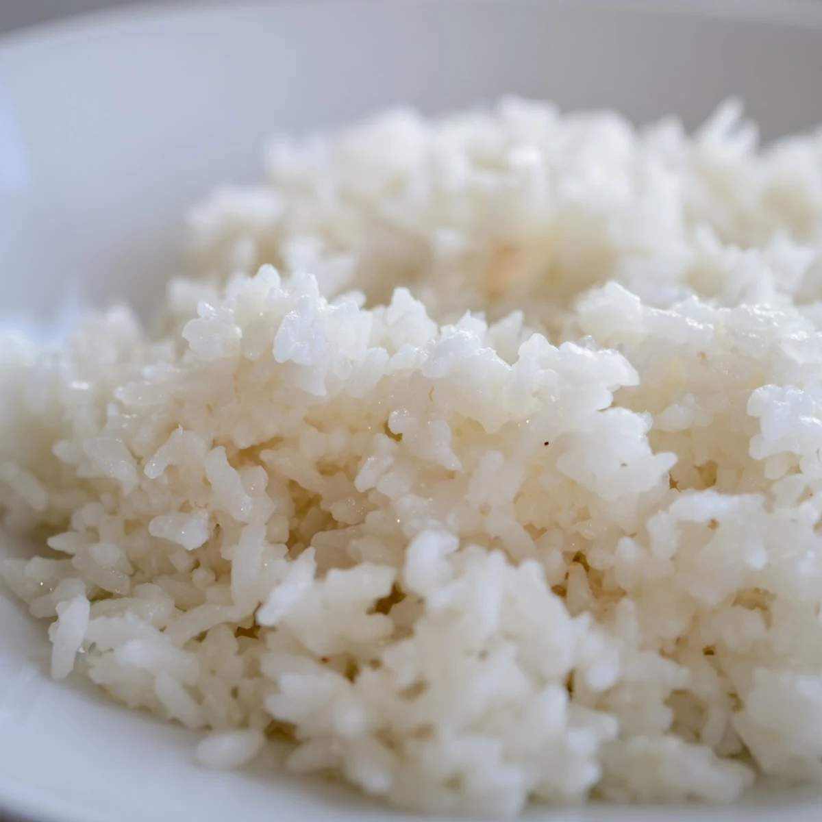 Steaming The Best Coconut Rice served alongside a colorful vegetable curry and fresh cilantro garnish.