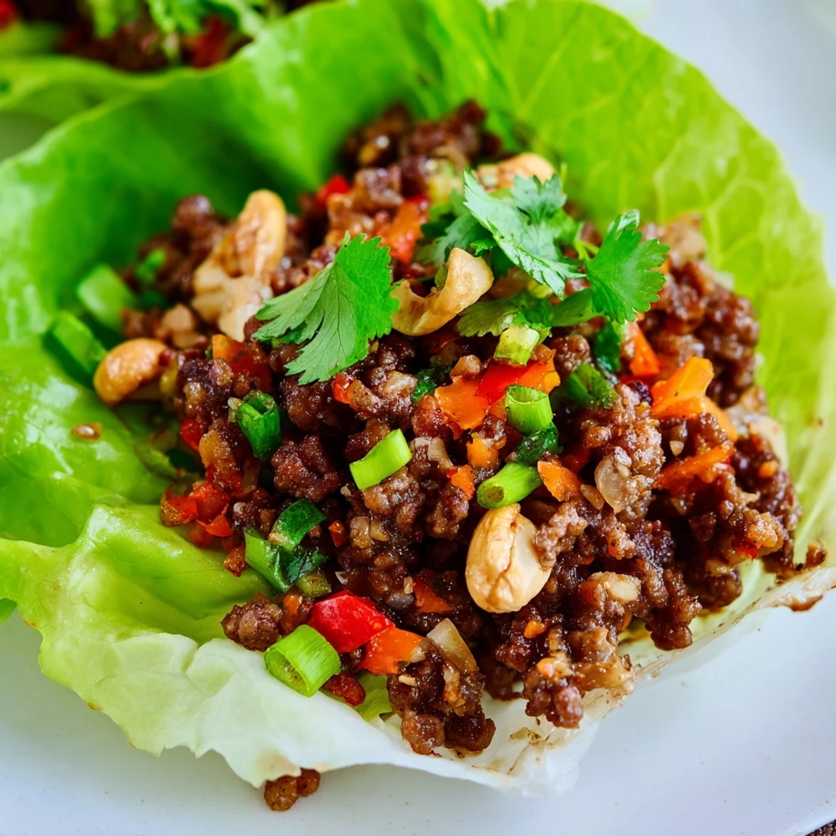 Crisp lettuce cups piled high with savory ground beef, crunchy roasted cashews, and vibrant diced vegetables.