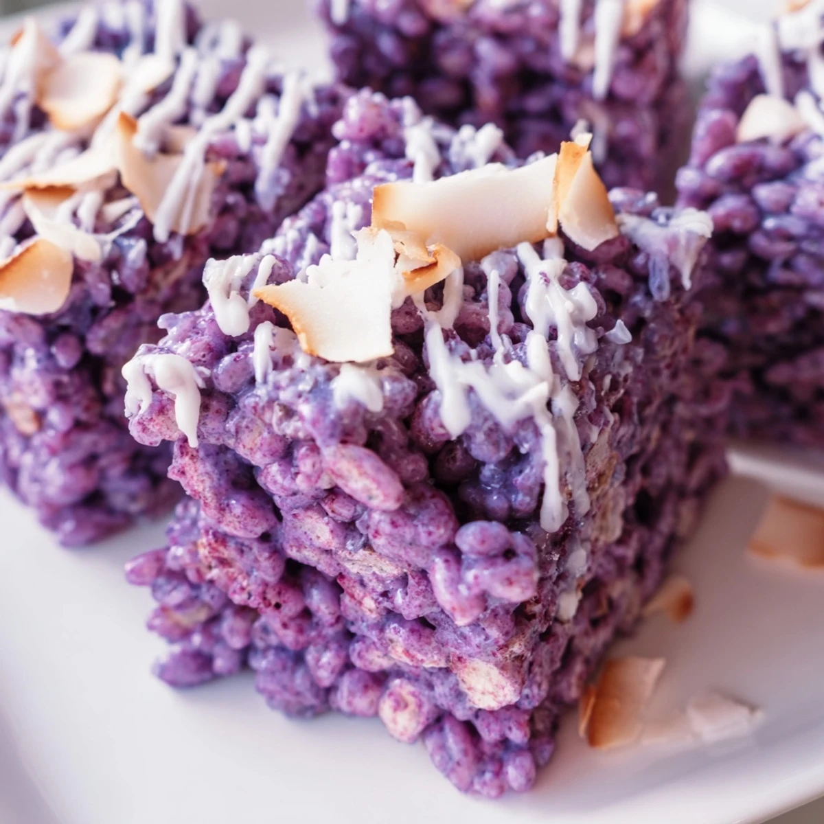 Freshly cut ube rice krispie treats arranged on serving platter with white chocolate swirls