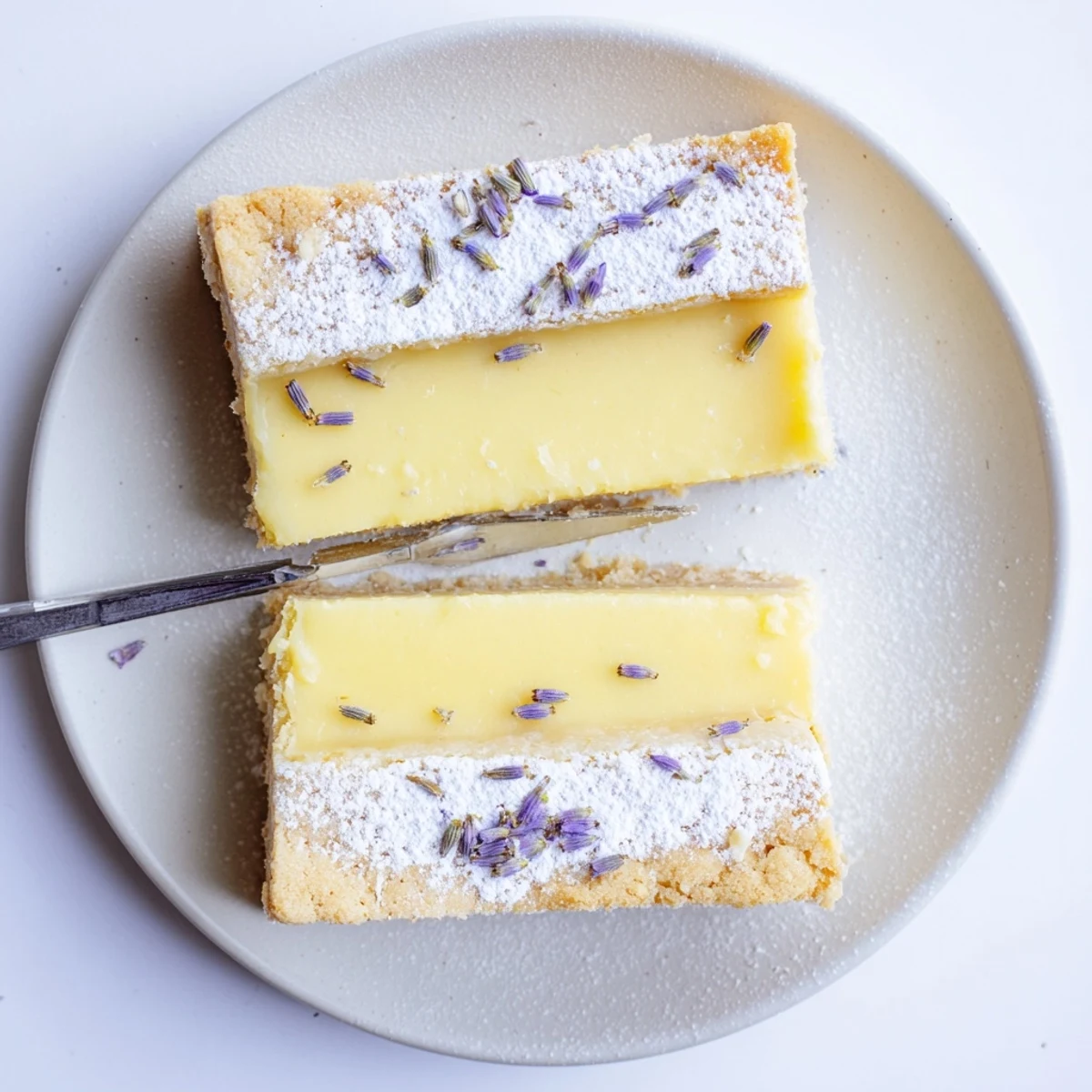 Buttery crust topped with creamy lemon lavender filling sliced into elegant rectangular bars