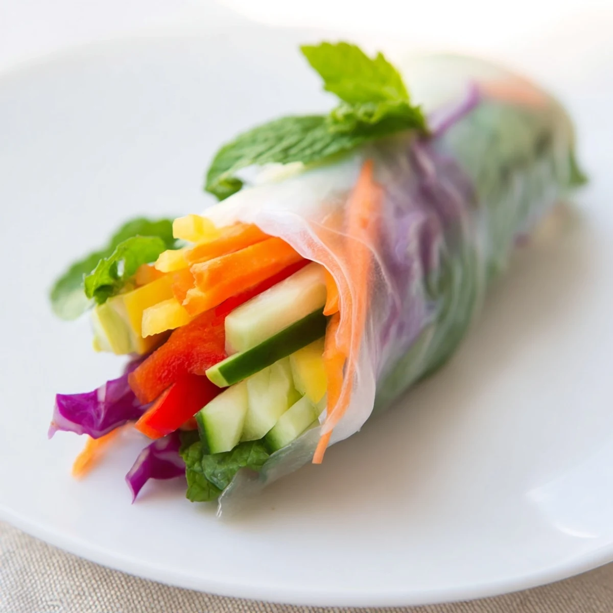 Vietnamese fresh spring rolls arranged on white plate alongside creamy peanut dipping sauce for serving