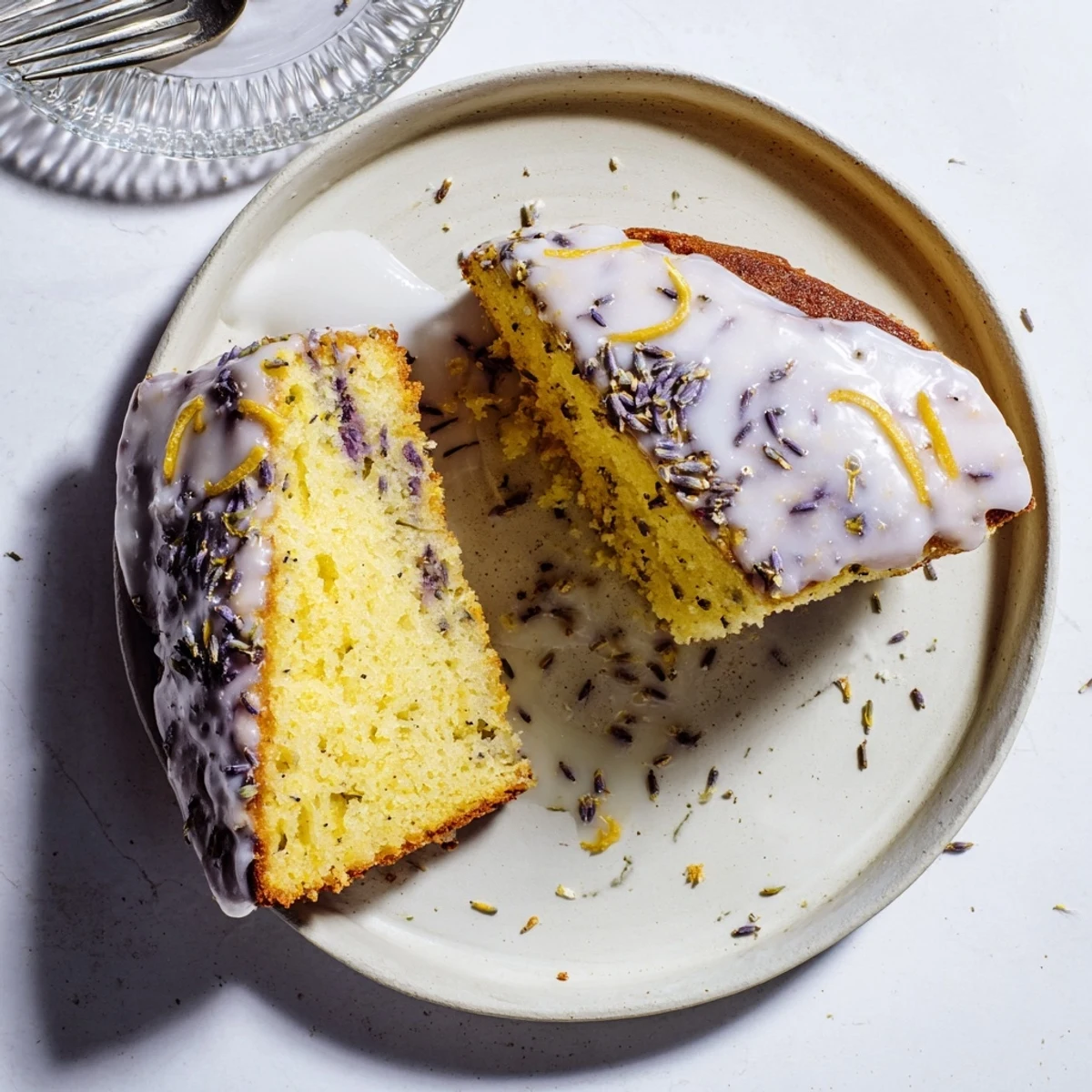 Moist lemon lavender cake drizzled with white glaze and sprinkled with purple lavender buds