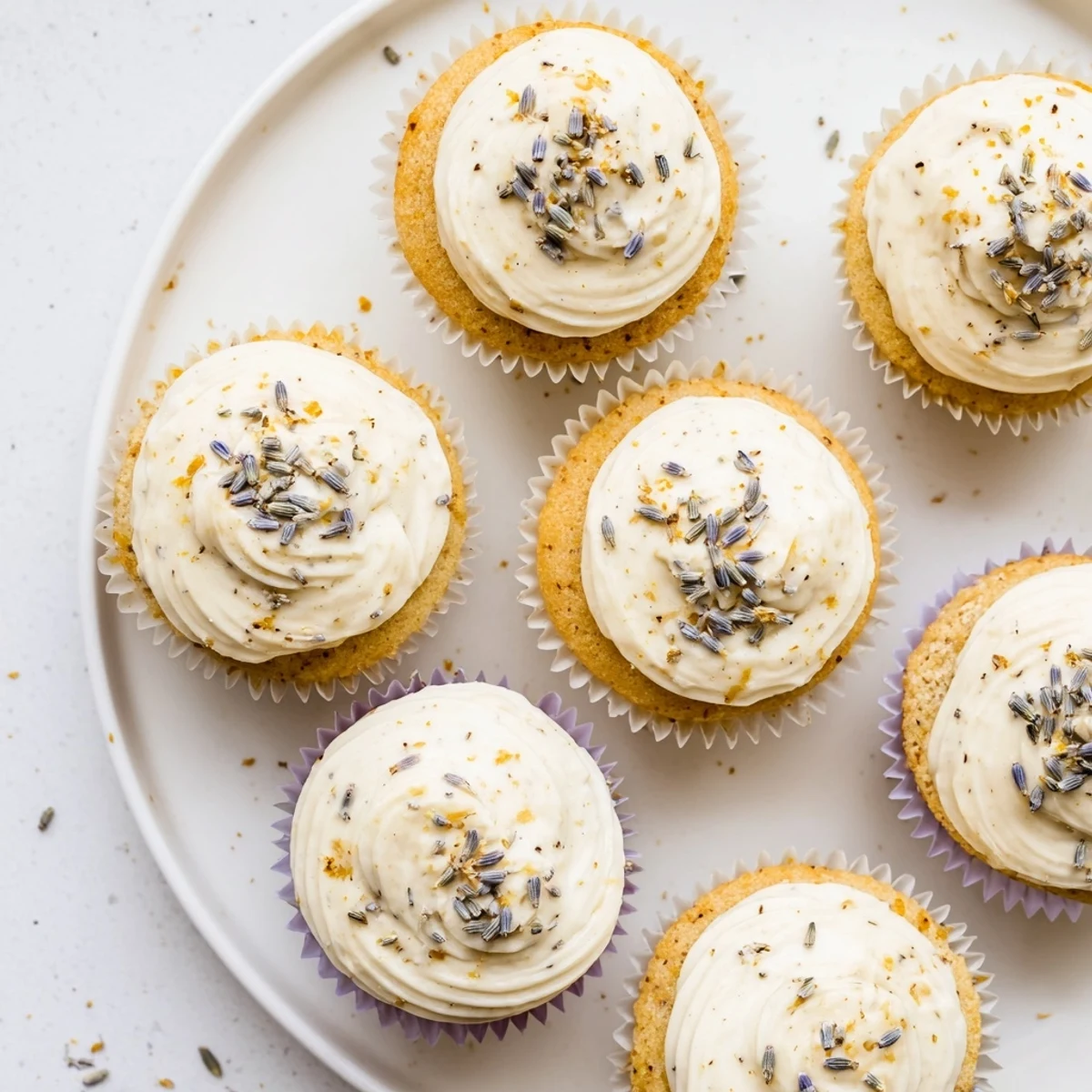 Golden lemon lavender cupcakes with light citrus buttercream and scattered purple lavender buds