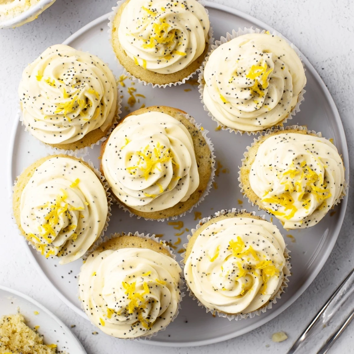 Moist homemade lemon poppy seed cupcakes with speckled batter and tangy cream cheese topping