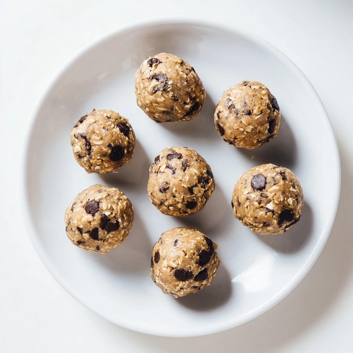 Bite-sized no-bake chocolate chip cookie dough protein balls rolled and ready for healthy snacking