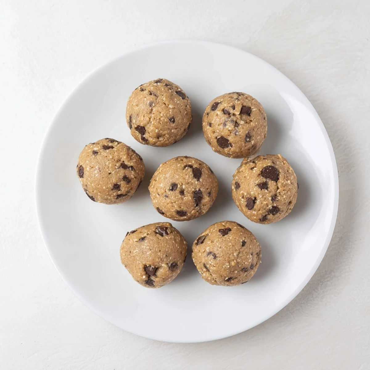 Homemade cookie dough protein bites arranged on a wooden board for easy grab-and-go snacks