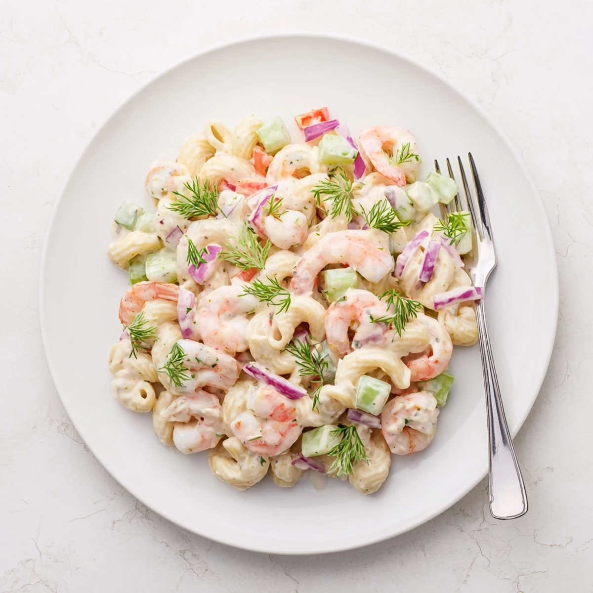 Creamy shrimp pasta salad featuring tender shrimp, crisp vegetables, and tangy dressing in a serving bowl