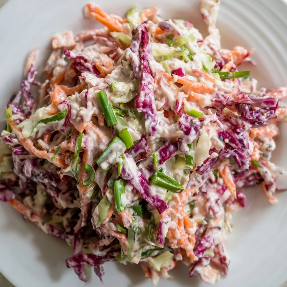 Creamy coleslaw salad topped in white dressing served at summer barbecue or picnic