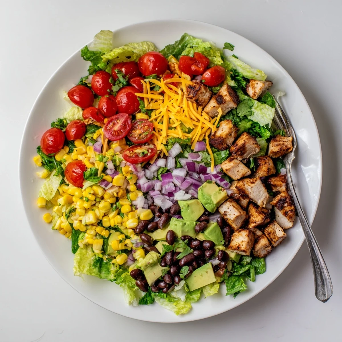 Vibrant Healthy BBQ Chicken Chopped Salad with charred BBQ chicken pieces, avocado, tomatoes, and tangy yogurt dressing