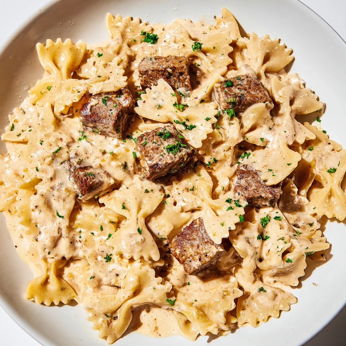 Tender farfalle noodles coated in spicy cream cheese sauce with paprika rubbed beef