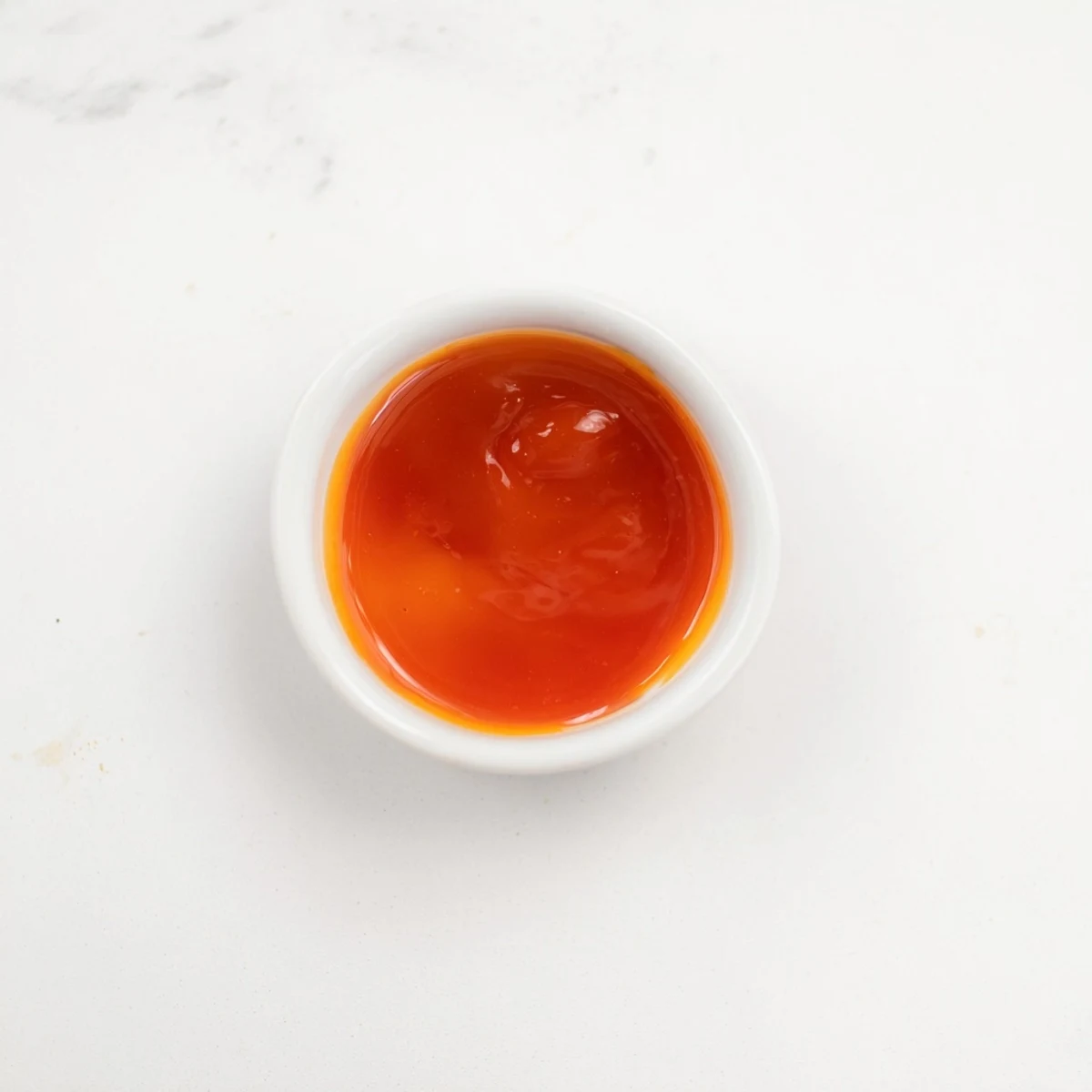 Rich orange McDonalds sweet and sour sauce drizzled over golden french fries on a wooden board