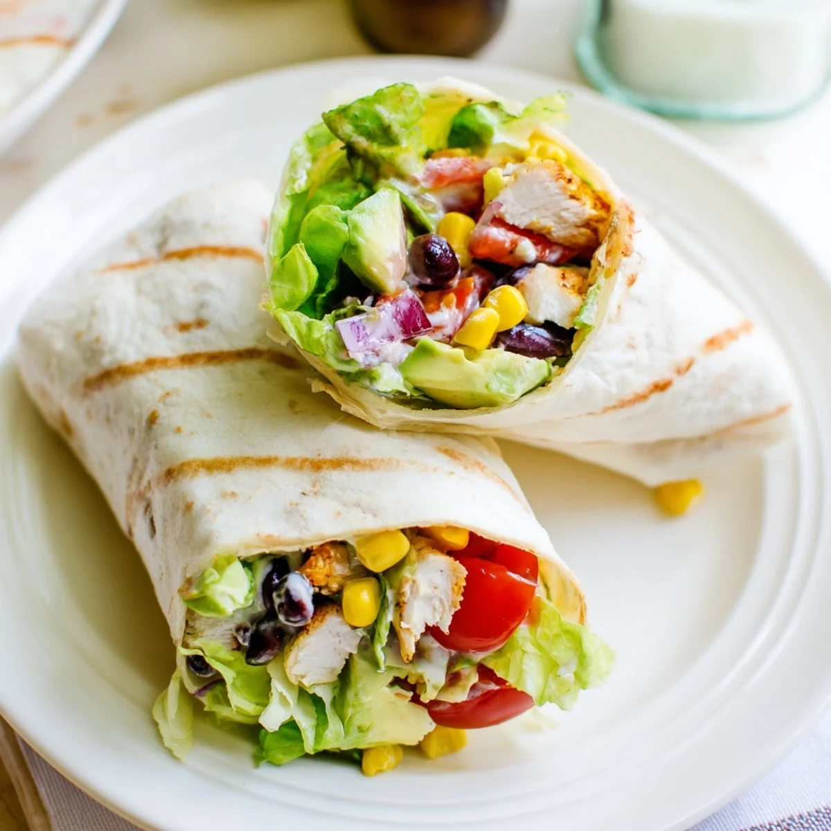 Homemade Southwest chicken wraps sliced in half showing vibrant layers of avocado and tomatoes