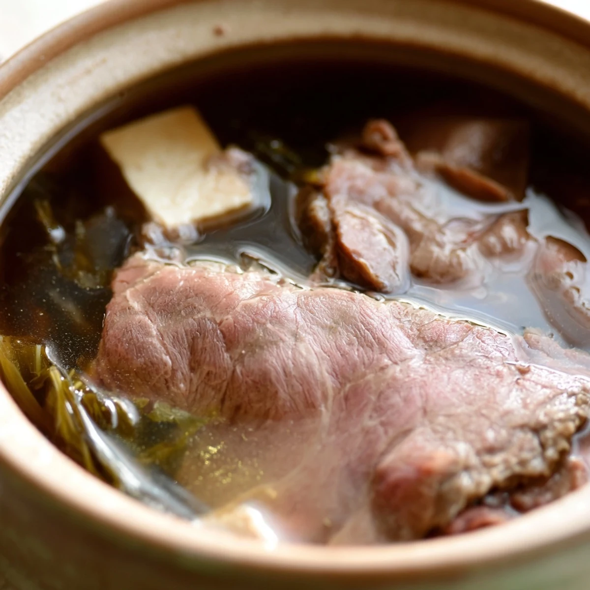 Interactive meal featuring diners swishing premium beef and crisp vegetables in aromatic broth for classic Japanese Shabu Shabu hot pot experience