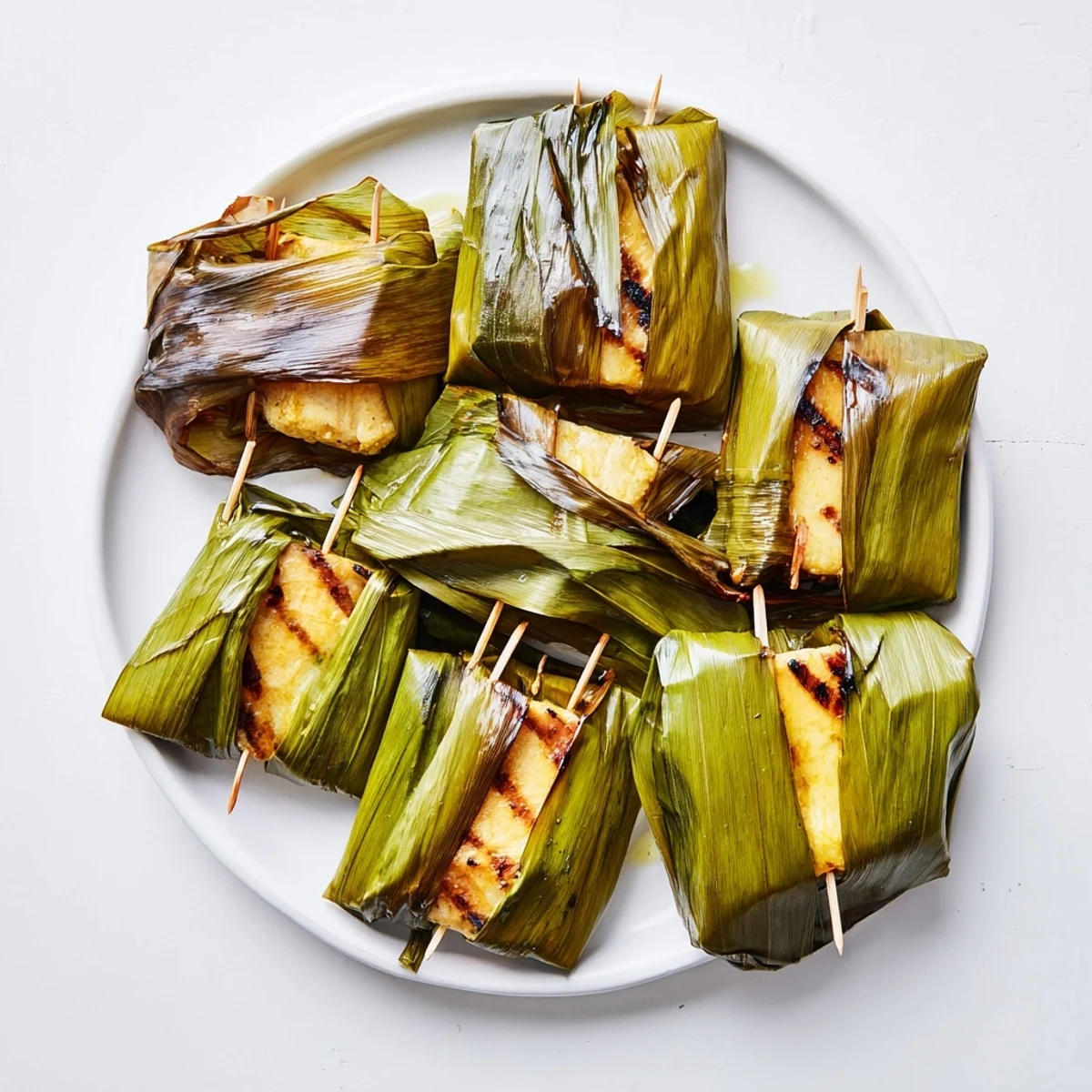 Golden grilled Malaysian Otak Otak custard with fragrant kaffir lime leaves served inside wilted banana leaf