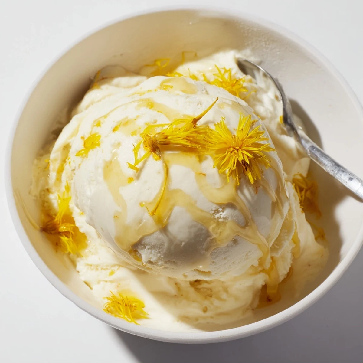 Golden scoops of floral dandelion honey ice cream drizzled with extra honey