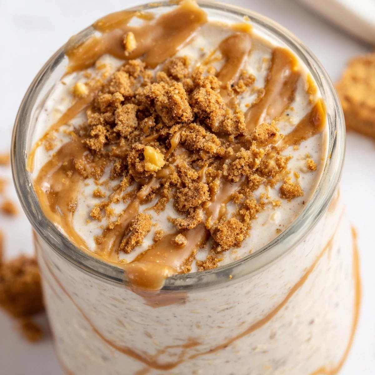 Biscoff overnight oats swirled with caramel spread and finished with crunchy crumbs