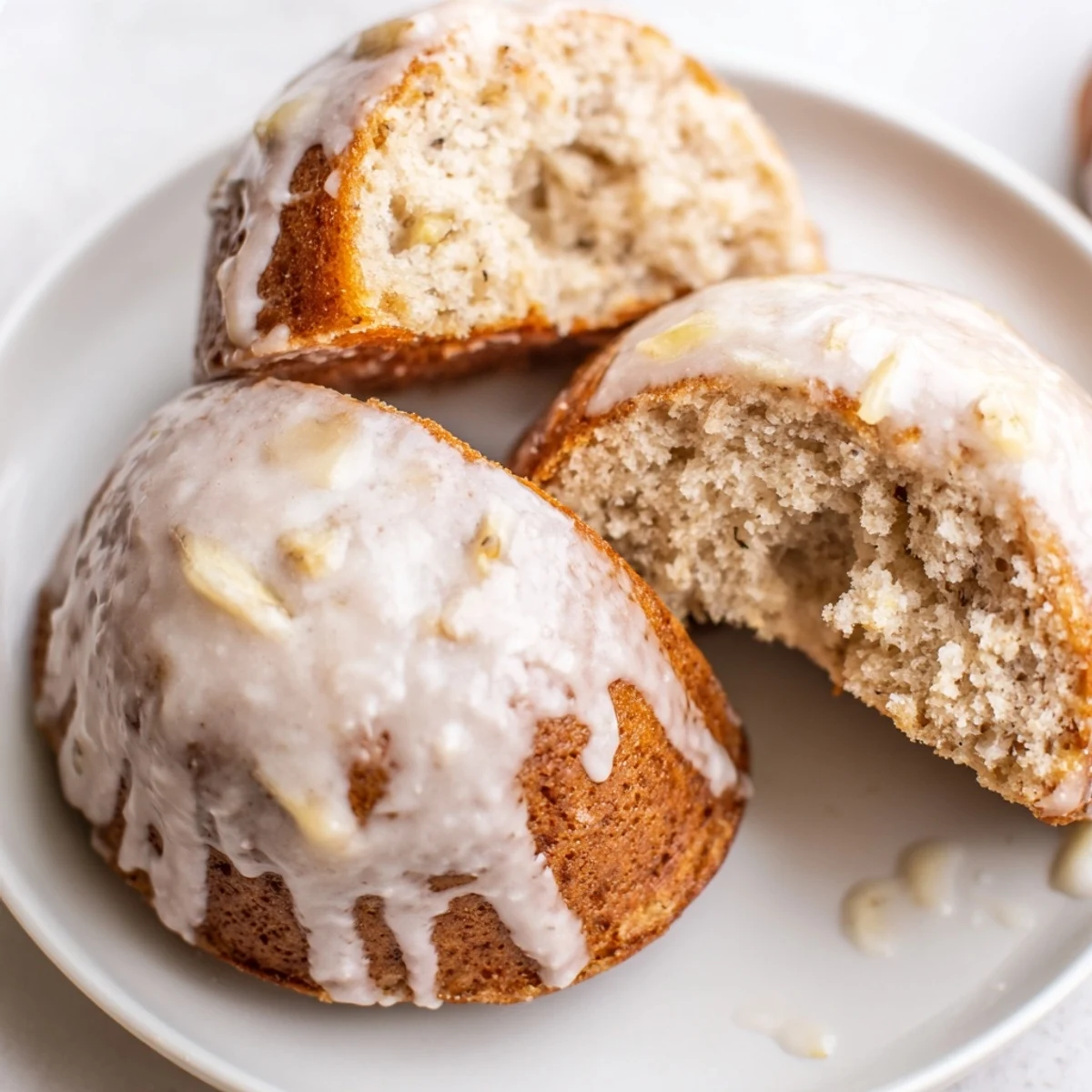 Glazed Banana Donuts arranged on a plate, moist crumb, glossy vanilla glaze