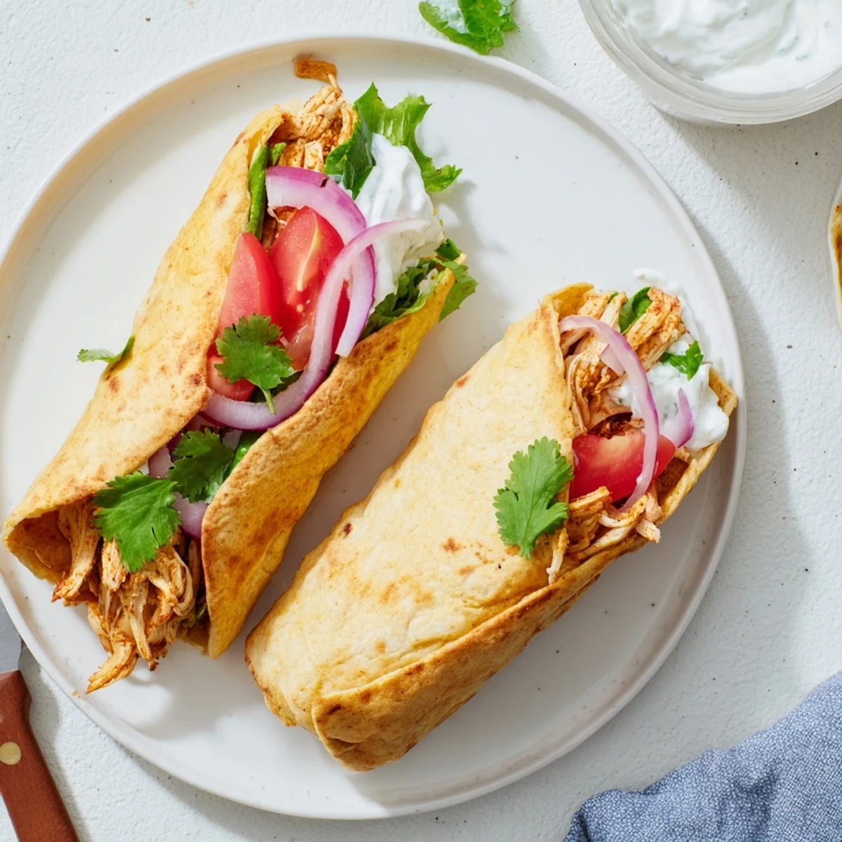 Spicy shredded chicken filling rolled inside crispy cottage cheese flatbread with vibrant vegetables