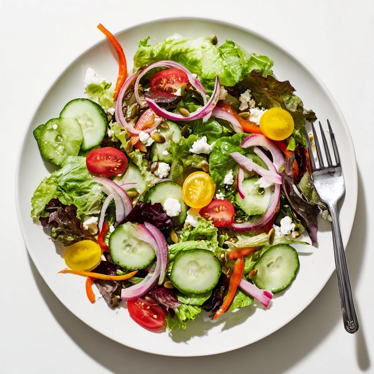 Colorful garden salad bowl with crisp greens, cherry tomatoes, cucumber, and tangy vinaigrette dressing