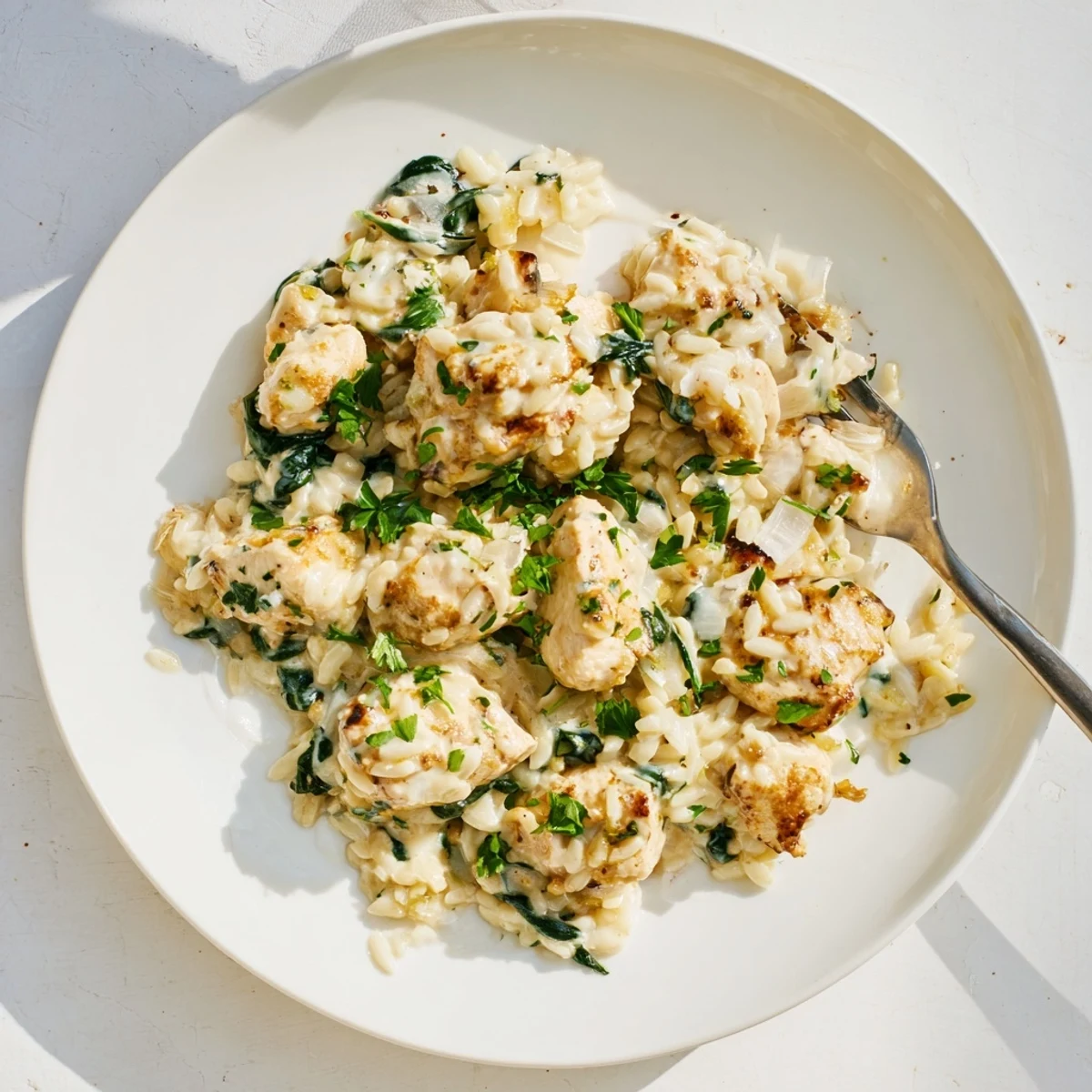 Creamy one pan Boursin chicken orzo with wilted spinach garnished with fresh parsley
