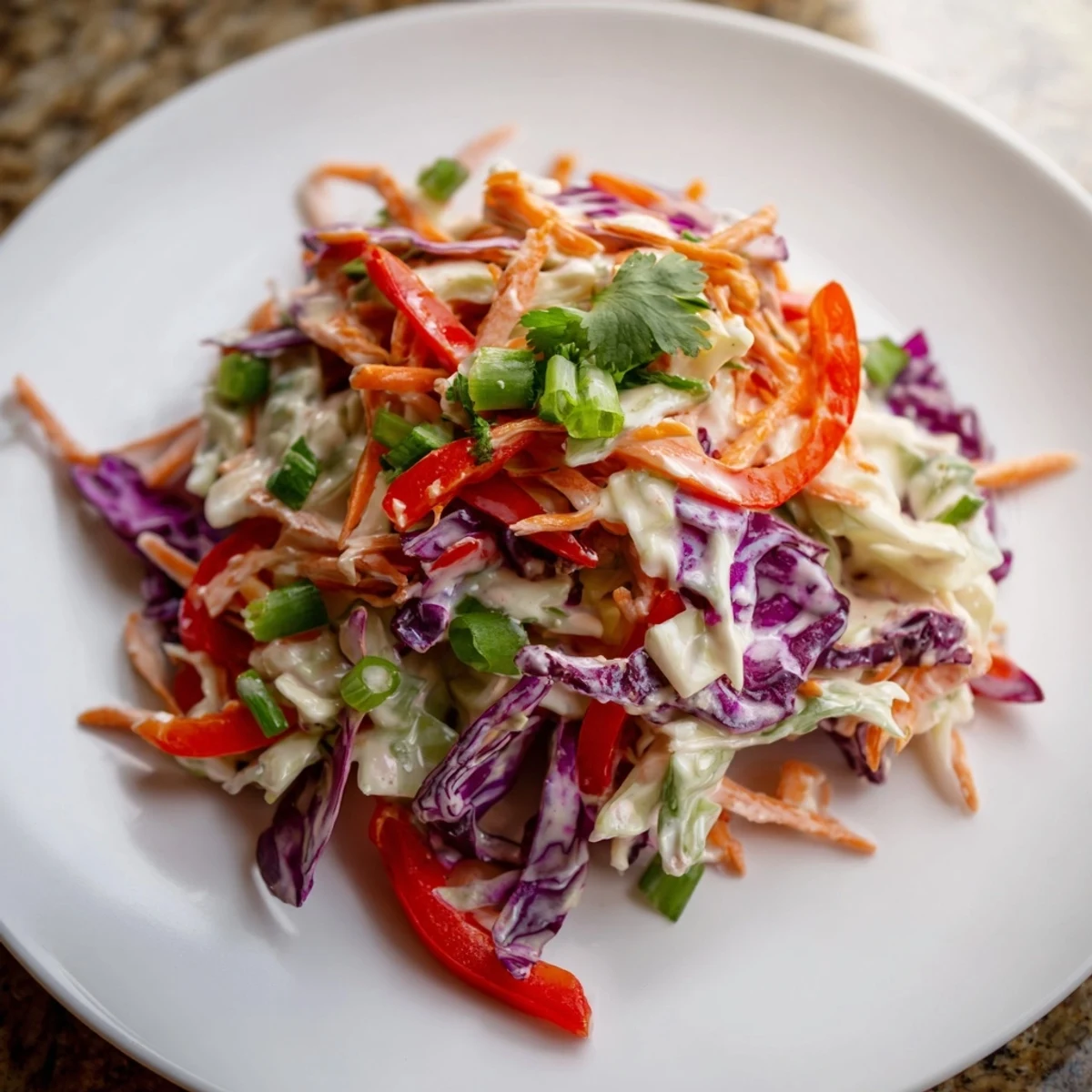 Colorful summer slaw with shredded cabbage, carrots, and peppers in a creamy honey dressing