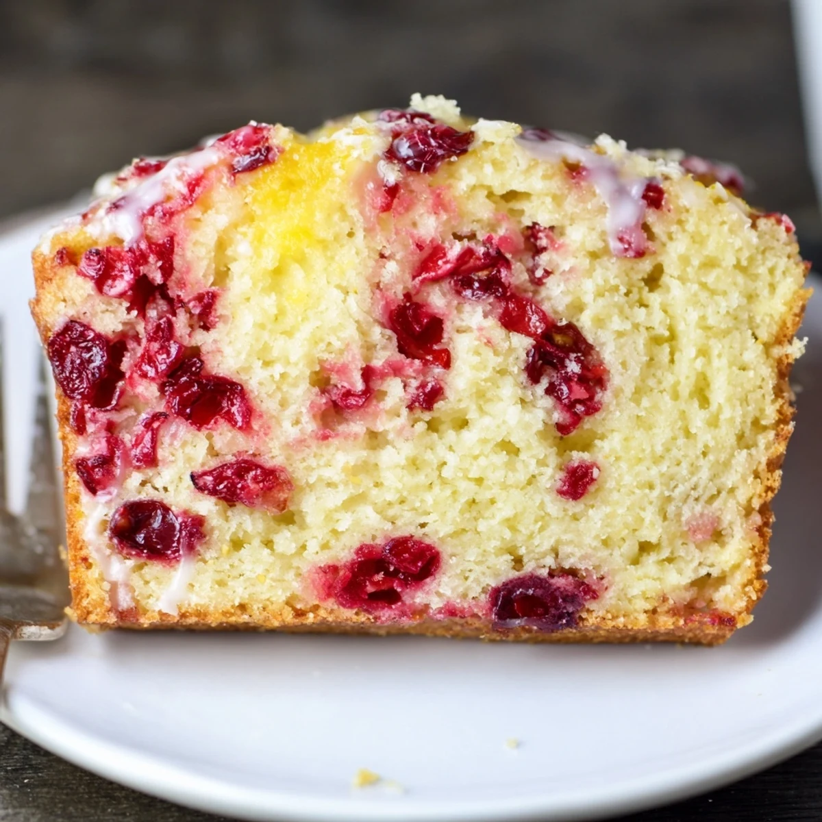 Cranberry Orange Bread cooling on wire rack, glossy orange glaze drips  
