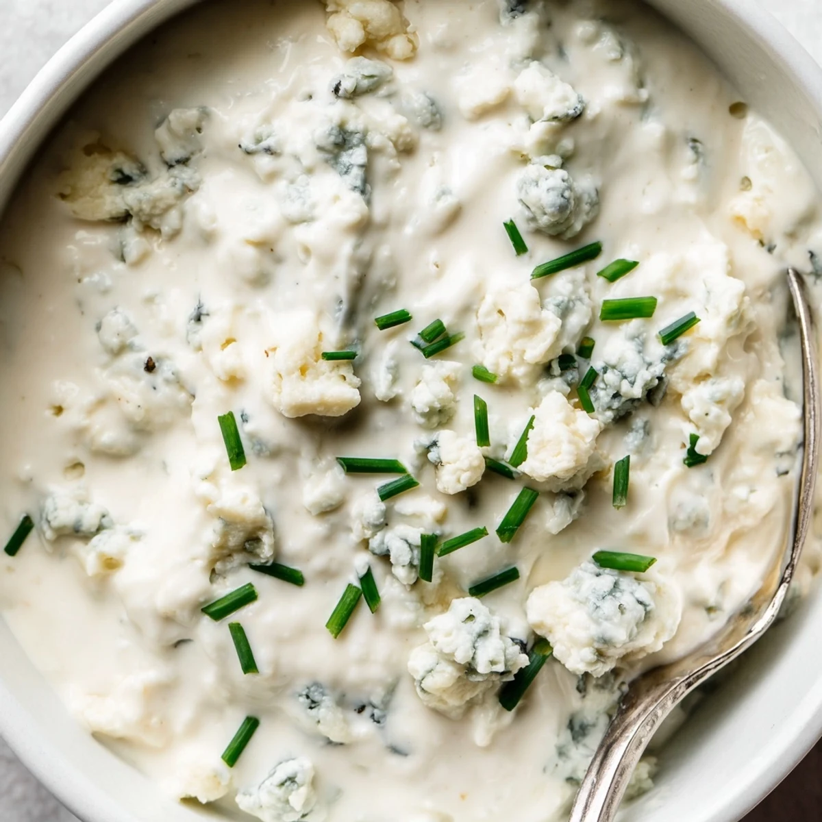 Thick blue cheese dip topped with chopped chives, served alongside crispy buffalo wings