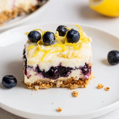 Slices of chilled Lemon Blueberry Lasagna Recipe topped with whipped cream and zest